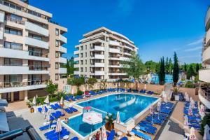 una imagen de una piscina en un hotel con sillas y apartamentos en condominio en Hermes Club Hotel - Ultra All Inclusive en Tsarevo