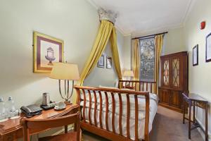 a bedroom with a bed and a desk with a telephone at Twenty Nevern Square Hotel in London