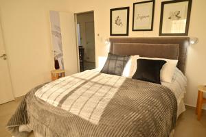 a bedroom with a bed with a gray and white comforter at Casa El Hornero Concepción del Uruguay in Concepción del Uruguay +21 photos