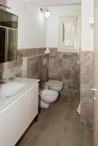 ein Badezimmer mit einem WC, einem Waschbecken und einem Spiegel in der Unterkunft Tana Dell'Orso in Ponsacco