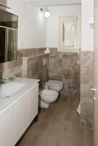 a bathroom with a toilet and a sink and a mirror at Tana Dell'Orso in Ponsacco