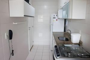 una pequeña cocina con fregadero y nevera. en Executive In - Ideal para família, en Río de Janeiro