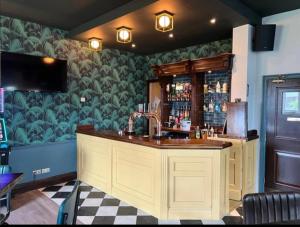 eine Bar in einem Restaurant mit grüner Wand in der Unterkunft The Wheatley Hotel in Doncaster