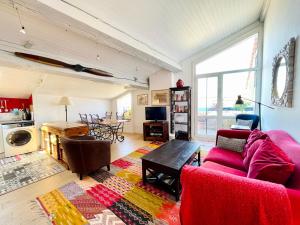 Bordeaux Terrace في بوردو: غرفة معيشة مع أريكة حمراء وطاولة