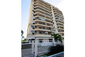 un grand immeuble avec une clôture blanche dans l'établissement Ideal para famílias! Muita segurança, à Rio de Janeiro