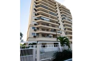 un edificio de apartamentos alto con una valla blanca en Loft Executivo - Ideal para família. en Río de Janeiro