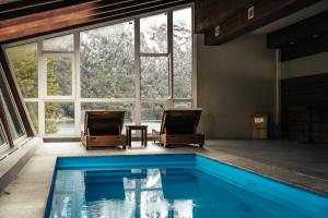 una casa con piscina en una habitación con ventanas en Hotel Puerto Blest en Puerto Blest