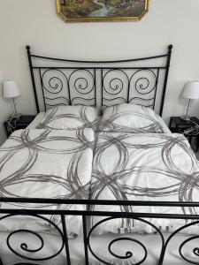 a black and white bed in a bedroom with two lamps at City Apartment 1 in Brühl