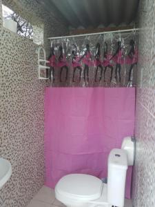 Baño de color rosa con aseo y lavamanos en Farah Camping Smartcamp hospedagem econômica en Boicucanga