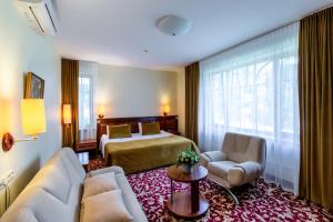een hotelkamer met een bed en een bank bij Hotel Violeta in Druskininkai