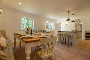 a dining room and kitchen with a table and chairs at The Long Cottage in Flitcham