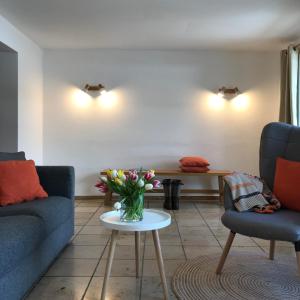 a living room with a vase of flowers on a table at Gästehaus Hotel Maria Theresia in Schliersee