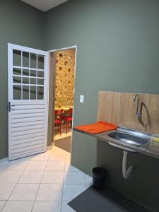 a kitchen with a sink and a door to a dining room at Casa Frida 1 in Natal