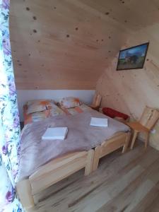 een slaapkamer met een bed in een blokhut bij Domki nad Borem in Ciche Małe