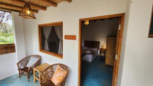 1 dormitorio y sala de estar con mesa y sillas. en Kinti Guest House en Máncora