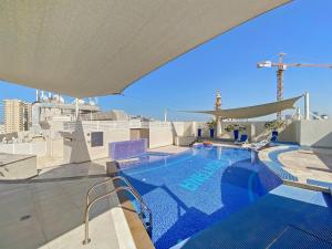 a swimming pool on the roof of a building at Brand New 2 Bedroom in La Fontana - 205 in Dubai