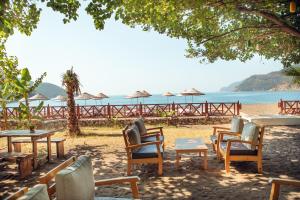 a group of chairs and tables on a beach at Eden Bungalows and Beach in Koycegiz