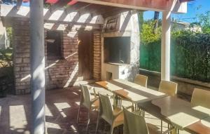 une terrasse avec une table, des chaises et une télévision dans l'établissement Stunning Home In Chamaret With Kitchen, à Chamaret