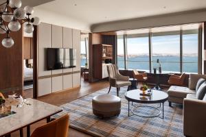a living room with a couch and a table at Four Seasons Hotel Dalian in Dalian