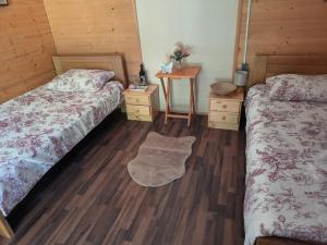 1 dormitorio con 2 camas y suelo de madera en JAGODA, en Popovača