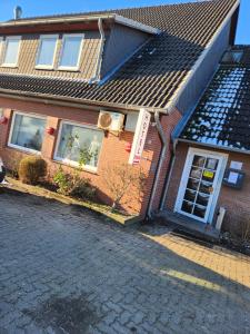 une maison en briques avec un toit dans une rue dans l'établissement Hotel & Restaurant Heidekrug in Pinneberg, à Appen