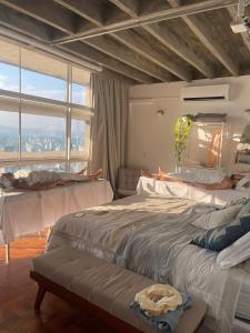 a bedroom with two beds and a large window at Vem pro Copan in Sao Paulo