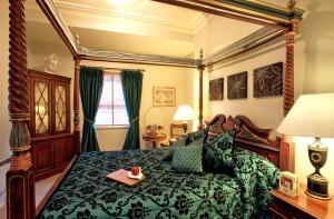 a bedroom with a green bed with a tray on it at Twenty Nevern Square Hotel in London