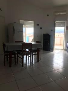 cocina con mesa, sillas y nevera en Comfort Home, en Capoterra