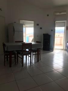 a kitchen with a table and chairs and a refrigerator at Comfort Home in Capoterra