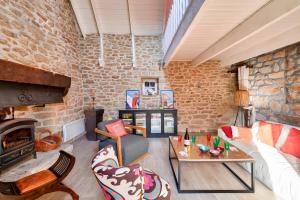 Una sala de estar con un sofá y una chimenea. en Escapade dans une belle longere a Penmarch, en Penmarch