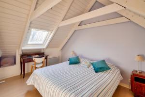 Dormitorio con cama y escritorio en el ático en Escapade dans une belle longere a Penmarch, en Penmarch