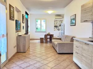 ein Wohnzimmer mit einem Sofa und einer Küche in der Unterkunft Portion of villa with garden, about 1km from the beach in Marina di Sorso