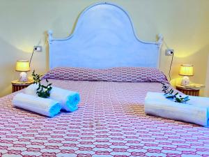 ein Schlafzimmer mit einem großen Bett mit zwei Kissen in der Unterkunft Portion of villa with garden, about 1km from the beach in Marina di Sorso