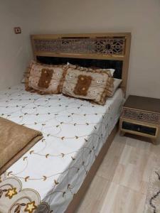 - une chambre avec un grand lit et des oreillers dans l'établissement شقه فندقية بالقرب من سيتى ستارز, au Caire