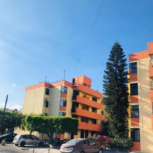 an apartment building with cars parked in a parking lot at Departamento Glorieta La Normal in Guadalajara