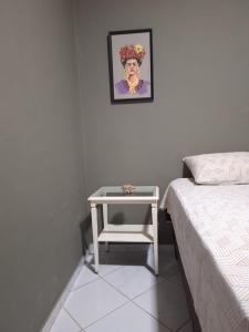 a bedroom with a table next to a bed and a picture at Casa Frida 3 in Natal