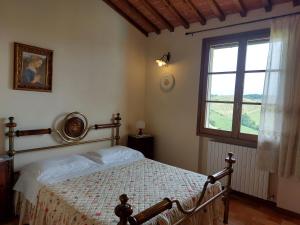 Schlafzimmer mit einem Bett und einem Fenster in der Unterkunft Agriturismo Corte in Poggio in Stabbia