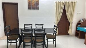 un tavolo nero con sedie in una stanza di Al Falah Homestay Kasaragod a Kāsaragod