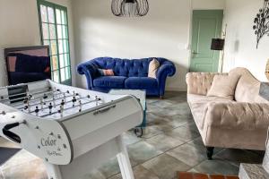 a living room with a foosball table and couches at Villa des Suisses with Jacuzzi & View of Lake des Settons in Moux-en-Morvan