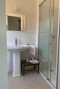 uma casa de banho com um lavatório e uma cabina de duche em vidro. em Le Clos des ifs em Thiétreville