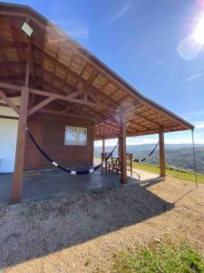 un pabellón de madera con una hamaca debajo en Aconchego Alto da Serra en Alfredo Wagner