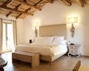 a bedroom with a large white bed with wooden ceilings at Hôtel Ambassador Palombaggia in Porto-Vecchio