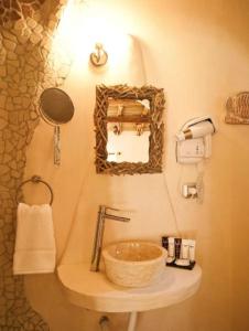 a bathroom with a sink and a mirror at Hôtel Ambassador Palombaggia in Porto-Vecchio