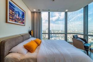 a bedroom with a bed with a large window at Landmark 81 And Vinhomes PANORAMA - ANGIA Hospitality in Ho Chi Minh City