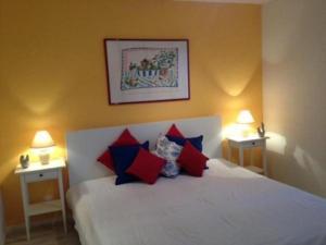 een slaapkamer met een wit bed met rode en blauwe kussens bij Casa Viola Panoramawohnung 1 Stock in Losone