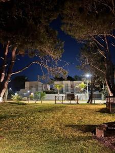a park with a bench and trees at night at Casa a 30 metros de la playa in Ciudad de la Costa