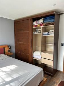 a bedroom with a bed and a closet with shelves at Casa a 30 metros de la playa in Ciudad de la Costa
