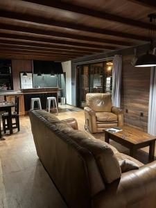 sala de estar con sofá de cuero y mesa en Casa a 30 metros de la playa, en Ciudad de la Costa