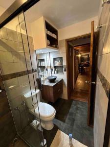 a bathroom with a toilet and a glass shower at Casa a 30 metros de la playa in Ciudad de la Costa