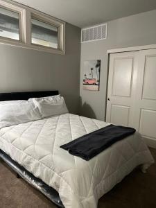 a bedroom with a white bed with a black blanket on it at Masterkeys Rentals LLC in Indianapolis